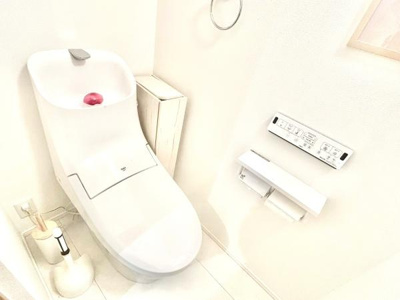 シンプルで清潔感のある印象のトイレです。壁のコントロールパネルで操作も簡単です。収納スペースが確保されています。ペーパーホルダーやブラシも備え付けられています。白を基調とした明るい空間です。