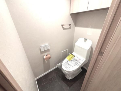 清潔感のあるトイレ空間です。手洗い一体型の仕様で便利にご利用いただけます。収納スペースも確保され備品の整理に役立ちます。壁リモコン式で操作も簡単です。明るくシンプルな内装が特徴です。