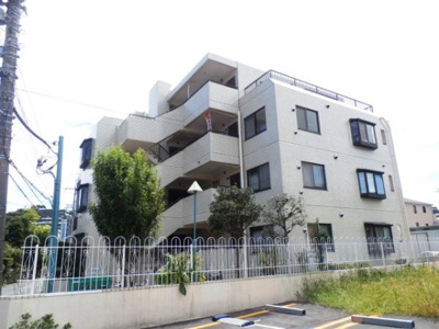 シンプルで落ち着いたデザインの外観が特徴です。建物周辺には植栽が施されており静かな雰囲気が感じられます。外壁は明るい色合いで清潔感が保たれています。複数台の駐車スペースも確保されています。