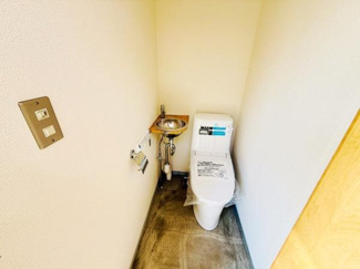 トイレ内に手洗いスペースが設けられており使い勝手が良い空間です。シンプルな内装が清潔感を演出しています。入口付近にスイッチが配置されていて便利です。床材はメンテナンスがしやすい仕様となっています。