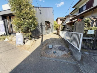 街路に面した現地写真です。周囲は住宅が立ち並ぶ落ち着いた雰囲気です。敷地へのアプローチも確保されており住環境を実感できる現地の様子がご覧いただけます。天候の良い日の撮影で明るさが感じられます。