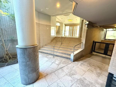 広々としたエントランスが印象的です。段差には手すりが設置されており安全面にも配慮されています。明るい照明と清潔感のある空間が出迎えます。建物全体の質感を引き立てるデザインです。