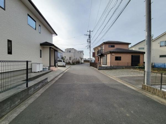 前面道路は舗装が整っており車の出し入れにも便利です。周囲には戸建て住宅が並び落ち着いた雰囲気が感じられます。電柱や配線もきちんと整備されていて安心感があります。敷地へのアクセスもしやすい立地です。