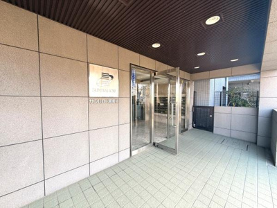 エントランスは広々とした設計で重厚感のあるタイル張りが特徴です。ガラス扉が採用されており開放的な雰囲気があります。屋根付きのスペースなので天候に左右されにくい設計です。