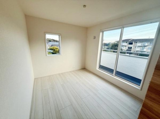 大きな窓から光がたっぷり差し込む洋室です。明るく開放的な空間が広がっています。シンプルな内装でお好みに合わせたインテリアが楽しめます。窓の外には周辺の景色も広がります。