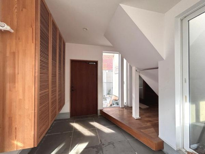 自然光が差し込む明るい玄関です。木の質感が空間に温かみを与えています。玄関収納も充実しておりすっきりとした印象です。玄関ホールの広がりが感じられる設計です。