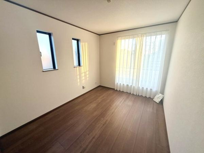 二面採光で明るさを確保した洋室です。シンプルな内装が幅広いインテリアに合わせやすい空間です。落ち着いた色合いの床材が特徴的です。窓からの光が心地よく差し込みます。