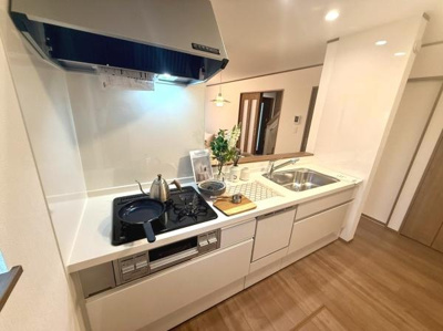 爽やかな色合いが印象的なキッチンです。シンプルで清潔感のある雰囲気です。ゆとりのある作業スペースが確保されています。収納も豊富に備えられています。明るい室内で快適に使えます。