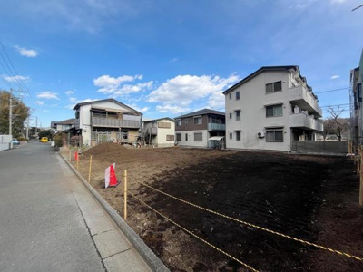 前面道路が広がる現地写真です。敷地と道路との接道状況もご確認いただけます。周辺には住宅が立ち並び落ち着いた雰囲気が感じられます。空が広く開放感のある立地です。