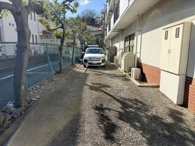 建物の側面に広がるスペースが印象的です。日当たりの良い環境で明るさを感じられます。車両の出入りもしやすい広さが確保されています。周囲は落ち着いた雰囲気が漂っています。