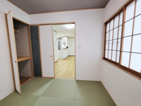 和室に設けられた収納スペースは扉付きで使い勝手に優れています。部屋全体がすっきり見えるデザインです。木目調の仕上げが落ち着いた雰囲気を与えています。