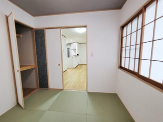 和室に設けられた収納スペースは扉付きで使い勝手に優れています。部屋全体がすっきり見えるデザインです。木目調の仕上げが落ち着いた雰囲気を与えています。