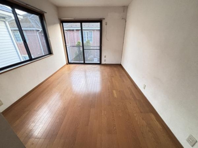 大きな窓からしっかりとした採光が得られる洋室です。床は木目調で落ち着きのある雰囲気になっています。壁面はシンプルでお好みのインテリアを楽しめます。広々とした空間で多彩な使い方が可能です。