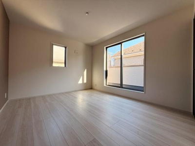 大きな窓からたっぷりと光が差し込む洋室です。床材のデザインが明るい印象を与えます。壁面は落ち着いた色合いでさまざまなインテリアに馴染みやすい空間です。二方向の窓により風通しも期待できます。