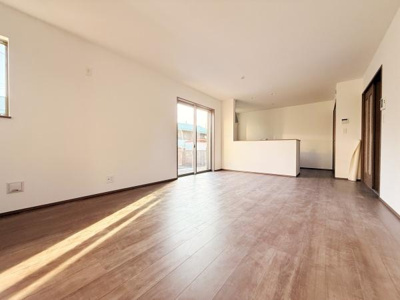 明るい日差しが差し込むリビングは広々とした空間が魅力です。大きな窓が開放感を演出し床材の色合いが落ち着いた雰囲気を生み出しています。キッチンへの動線もスムーズで使いやすさがあります。