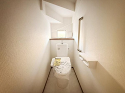 明るい光が差し込むトイレです。シンプルなデザインで清潔感があります。収納スペースも確保しやすい配置です。上部には開放感のある窓が設けられ空間に奥行きを感じられます。
