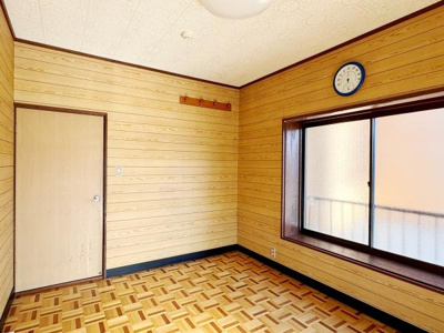 木目調の壁が温かみを感じさせる洋室です。大きな窓からはたっぷりと自然光が差し込みます。床のデザインが個性的で落ち着いた雰囲気を演出しています。収納やインテリアの配置も自由にアレンジできます。