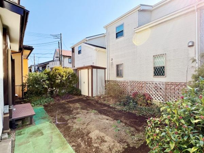 日当たりのよい庭が広がっており開放感を感じさせます。物置が設置されており収納にも便利です。緑に囲まれたスペースが落ち着いた雰囲気を演出しています。庭の手入れも楽しめる環境です。