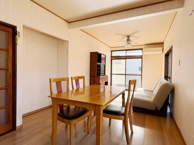 明るい日差しが差し込むリビングスペースです。ナチュラルな木目調の床が落ち着いた雰囲気を演出します。ダイニングテーブルとソファが配置され使いやすい空間設計です。