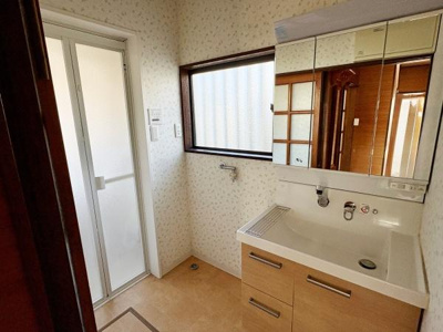 使いやすい洗面台と広めの鏡収納が特徴的です。窓があり自然光が入りやすい空間となっています。収納力のある洗面台が日々の身支度に便利です。室内は清潔感がありシンプルなデザインです。