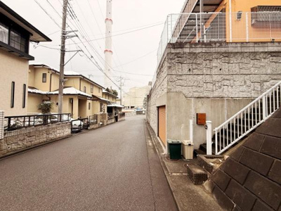 前面道路は幅がありゆったりとした印象です。周囲には住宅が立ち並び落ち着いた環境が感じられます。道路は舗装されており車の出入りもスムーズに行えそうです。現地周辺の様子も確認しやすい写真です。