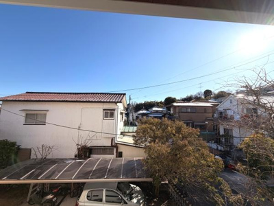 広々とした空と周囲の住宅が見渡せる現地からの眺望です。自然光が豊かに差し込み屋根付き駐車場が確認できます。落ち着いた住宅街ならではの景色が特徴です。空の開放感が感じられる眺望です。