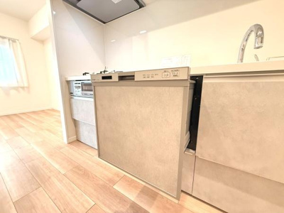 明るい空間が広がるキッチンです。食洗機が備え付けられており日々の家事をサポートします。シンプルなデザインでお手入れしやすく機能性も考慮されています。床材とキッチンパネルの調和が取れています。