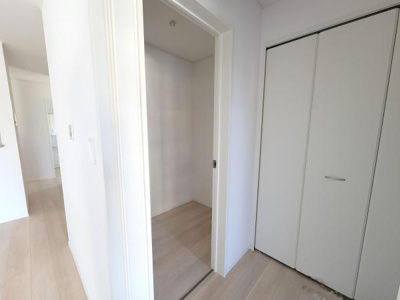 白を基調としたシンプルな収納スペースが設けられています。クローゼットと奥行きのある収納があり用途に応じて使い分けが可能です。居室からアクセスしやすい位置に収納が配置されています。