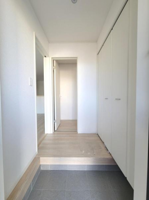 玄関は明るくすっきりとした印象です。大きな収納が備わっており整理整頓がしやすい空間です。シンプルなデザインが空間を広く見せています。床の色合いも落ち着いており様々なインテリアにも合わせやすいです。