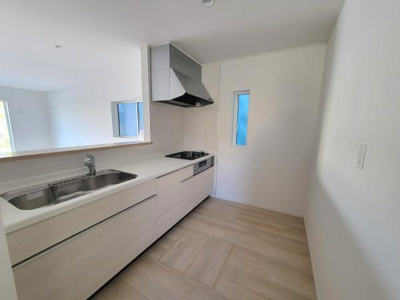 シンプルですっきりとしたデザインのキッチンです。収納スペースも豊富に備えています。明るい空間でお料理の際も快適に過ごせます。横長の窓から自然光が入る設計です。空間が広く清潔感があります。