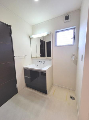 洗面台・洗面所は清潔感のあるシンプルなデザインです。大きな鏡と収納スペースが備わっていて使い勝手が良さそうです。窓があり採光にも配慮されています。