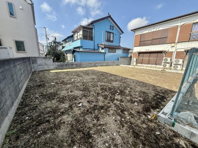 現地土地写真は見通しの良い区画になっております。周囲は住宅に囲まれており整形地としてご活用いただけます。日当たりや明るさも十分確保されています。周辺エリアの雰囲気もご確認いただける写真です。