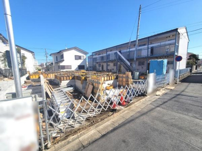 現地写真では建築中の様子が確認でき周辺の環境も一目で分かります。前面道路がしっかりと舗装されており道幅も確認しやすいです。現場周辺は整理されていて工事の進捗も把握できる写真です。