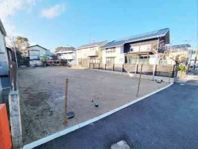 開放感のある現地土地写真です。周囲には住宅が立ち並び日当たりも期待できる環境です。道路に面しておりアクセスもしやすくなっています。