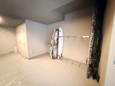 サーフボード専用の収納スペースが用意されており趣味を大切にしたい方におすすめの環境です。壁掛けラックが設置されているため整理整頓がしやすい仕様です。室内の明るい色調が清潔感を演出しています。