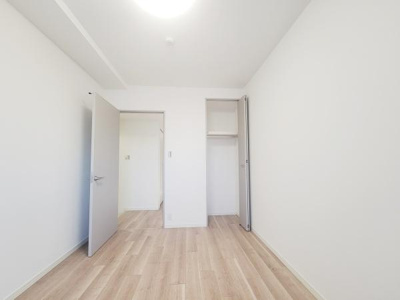 ナチュラルな床材が特徴の洋室です。明るい色調の壁と天井で開放感があります。収納スペースも確保されており整理整頓しやすい雰囲気です。シンプルな設計でさまざまなインテリアに対応可能です。