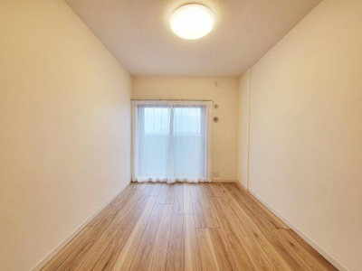 すっきりとした形状の洋室で開放感のある空間です。大きな窓から自然光が入り明るい雰囲気となっています。木目調の床が温かみを感じさせインテリアのアレンジもしやすい仕様です。