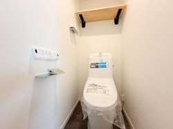 シンプルなデザインのトイレで清潔感があります。壁には便利な棚が設けられており小物置きとして活用できます。