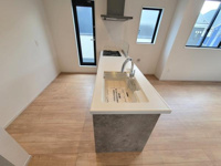 シンプルで洗練されたキッチンは空間をすっきりと見せます。明るい採光で作業しやすい環境です。カウンター部分が広く日常の使い勝手にも配慮されています。床材とのコントラストが特徴的です。