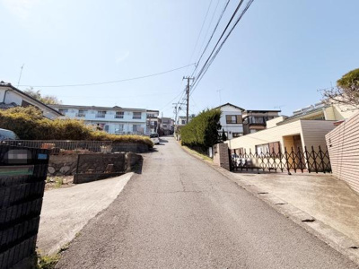 前面道路は幅が広く車の出入りもスムーズに行えます。周囲には住宅が立ち並び落ち着いた雰囲気が感じられます。電柱や電線も整理されており視界が開けています。現地の環境を実際にご覧いただけます。