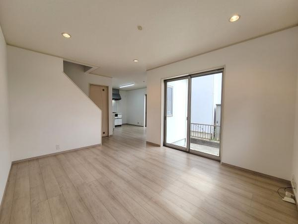 広々としたリビングは窓からやわらかな光が差し込み明るい雰囲気が魅力的です。フローリングと壁のコントラストが空間をすっきりとまとめています。