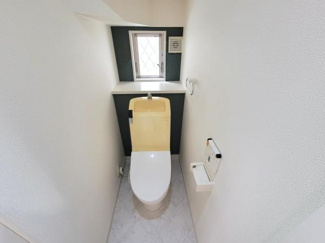 シンプルで使いやすいトイレ空間です。小窓があり採光と換気が確保されています。ペーパーホルダーやリモコンも手の届きやすい位置に設置されています。落ち着いた雰囲気の内装です。