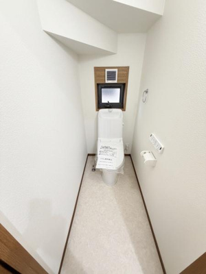明るい雰囲気のトイレです。小窓付きで採光と換気に配慮されています。壁の色が清潔感を演出しています。スペースが効率的に活用されています。シンプルなデザインが好印象です。