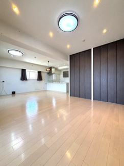 床暖房付きの暖かな約24帖のシンプルで過ごしやすいリビング。各所にダウンライトが設置されており、明るくもどこか落ち着いた印象になります。