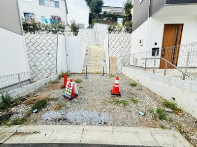 前面道路に面した敷地でアクセスしやすい配置です。周囲にはしっかりとした擁壁が設置されています。階段があり高低差のある立地です。敷地内の管理も行き届いています。