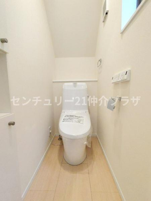 清潔感のあるトイレ空間です。ホワイトを基調とした内装で明るい印象があります。タンク一体型でお手入れもしやすい設計となっています。ペーパーホルダーやリモコンも手の届く位置に配置されています。