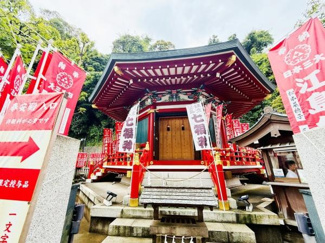 鮮やかな赤が印象的な外観で伝統的な雰囲気を感じられる建物です。緑に囲まれた立地で四季折々の自然も楽しめます。朱色の旗や欄干が印象的で存在感のある神社です。石造りの参道や階段が趣を添えています。