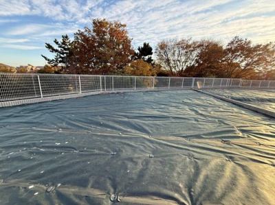 開放感のある現地土地写真です。敷地全体がしっかり確認できる視界の広い眺めが特徴です。フェンスが設置されており安全面にも配慮されています。周囲には自然があり季節の移ろいも感じられます。