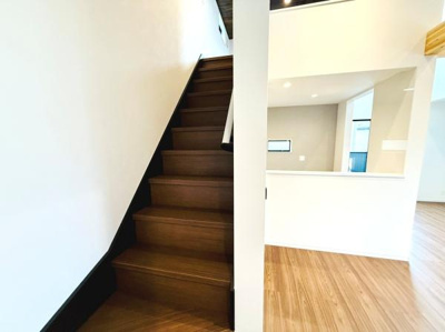 階段部分は落ち着いた木目調で室内の雰囲気と調和しています。段差の高さも均一で使いやすい仕様です。階段横の壁が空間をしっかり仕切っておりプライベートな動線も確保できます。