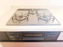 三口コンロが備わったキッチンで調理の際の使い勝手に配慮されています。シンプルなデザインでお手入れがしやすい構造です。調理スペースも確保されており様々な料理に対応できます。
